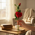 A premium artificial red rose stem with a blooming flower and a bud held in a hand.