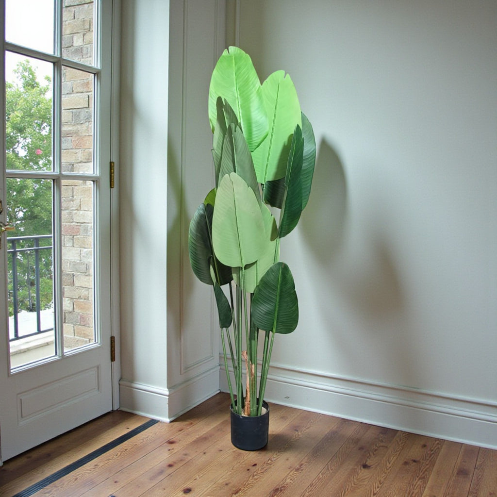 Tall artificial Traveller’s Palm tree with large, upright green paddle-shaped leaves in a minimalist black cylindrical pot.