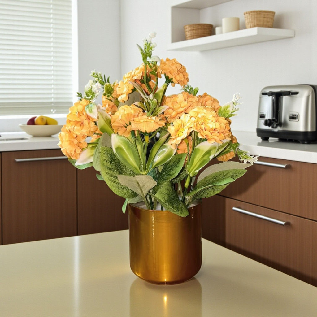 rtificial yellow flowers arranged in a cylindrical gold metal pot.